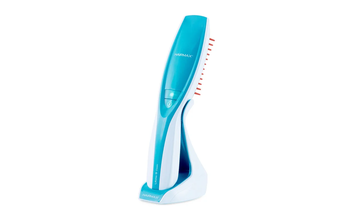 HairMax Ultima 9 Classic LaserComb standing in its charging cradle